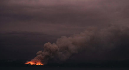 fire in the distance seen from the Royal Australian Navy’s HMAS Adelaide ship off the coast in Eden in New South Wales. Firefighters raced to quell massive bushfires in southeastern Australia on January 7, taking advantage of a brief drop in temperatures and some much-needed rainfall before another heatwave strikes later this week.