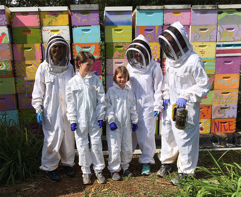 The author and her family during a visit to some of Robin Fisher’s bee hives on a farm on the Hawaiian island of Kauaʻi.